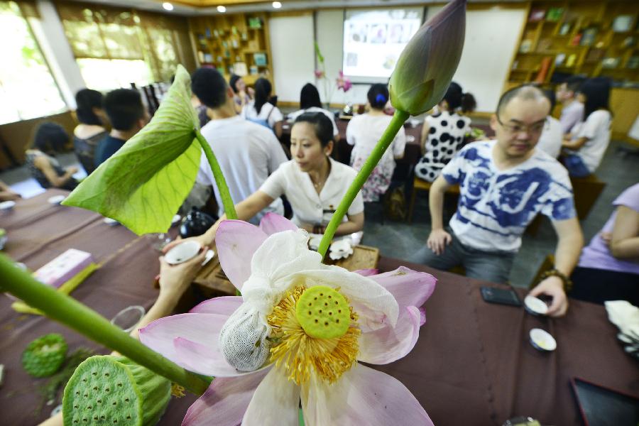 同类别的茶叶置于即将绽放的荷花花芯内或埋于鲜荷碎叶中吸取荷之清香