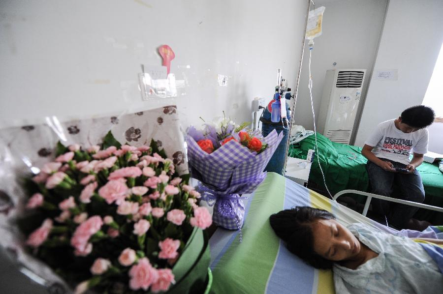 8月28日,祝鹏飞母亲的病床旁摆放着许多爱心人士送来的鲜花.